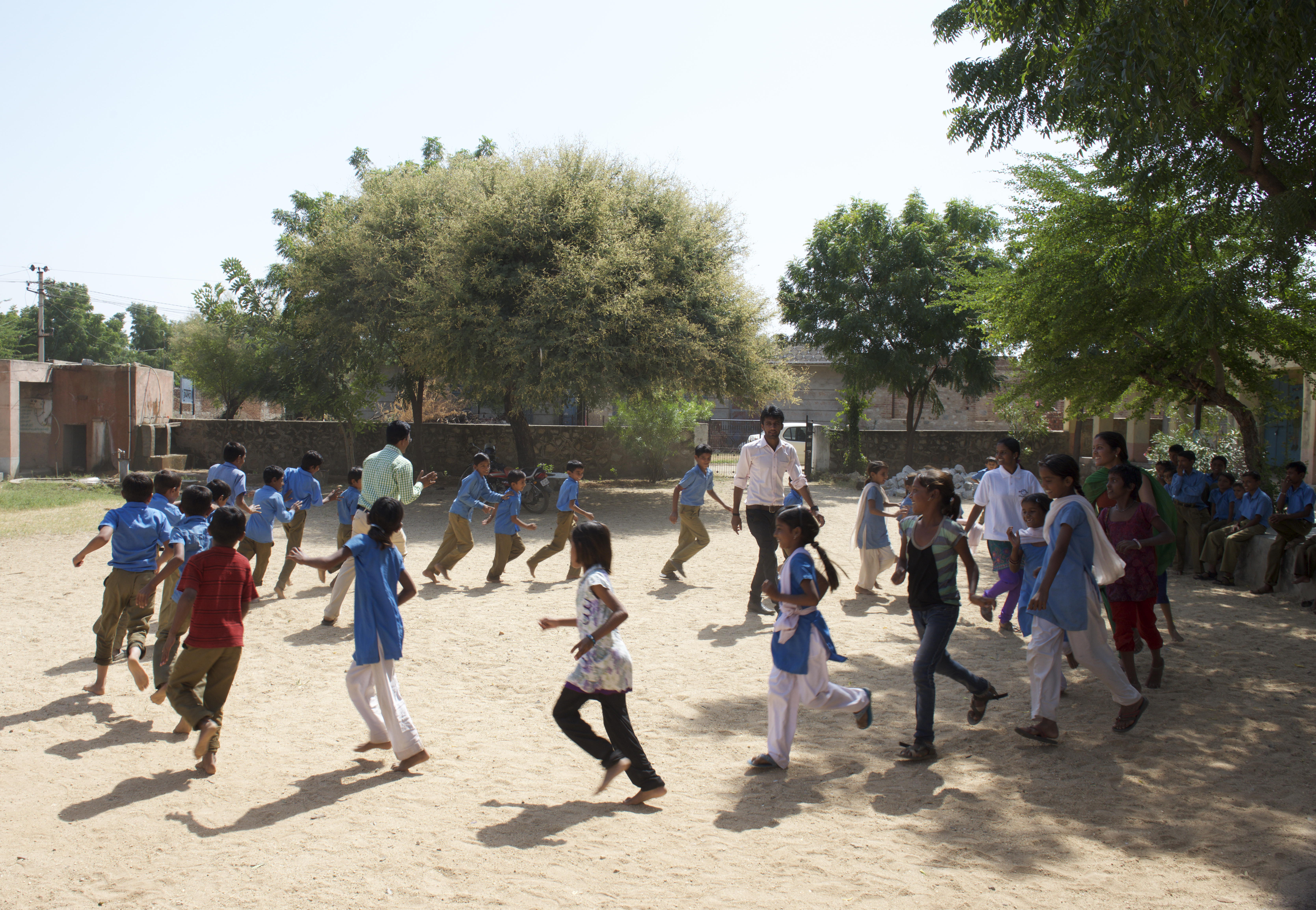 School children playing outside with Team Balika members